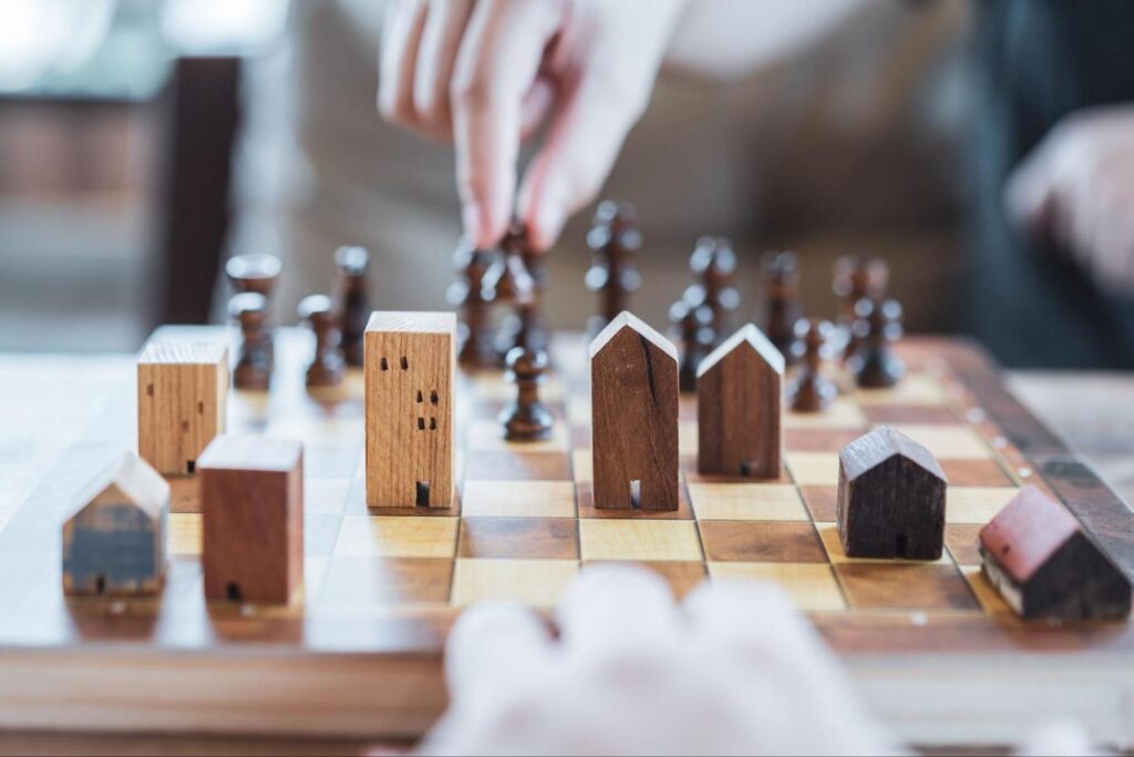 Playing chess using chess pieces shaped like real estate investments.
