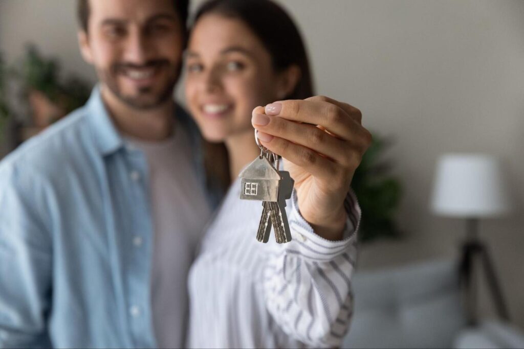 Couple holding a key, signifying they are homeowners.