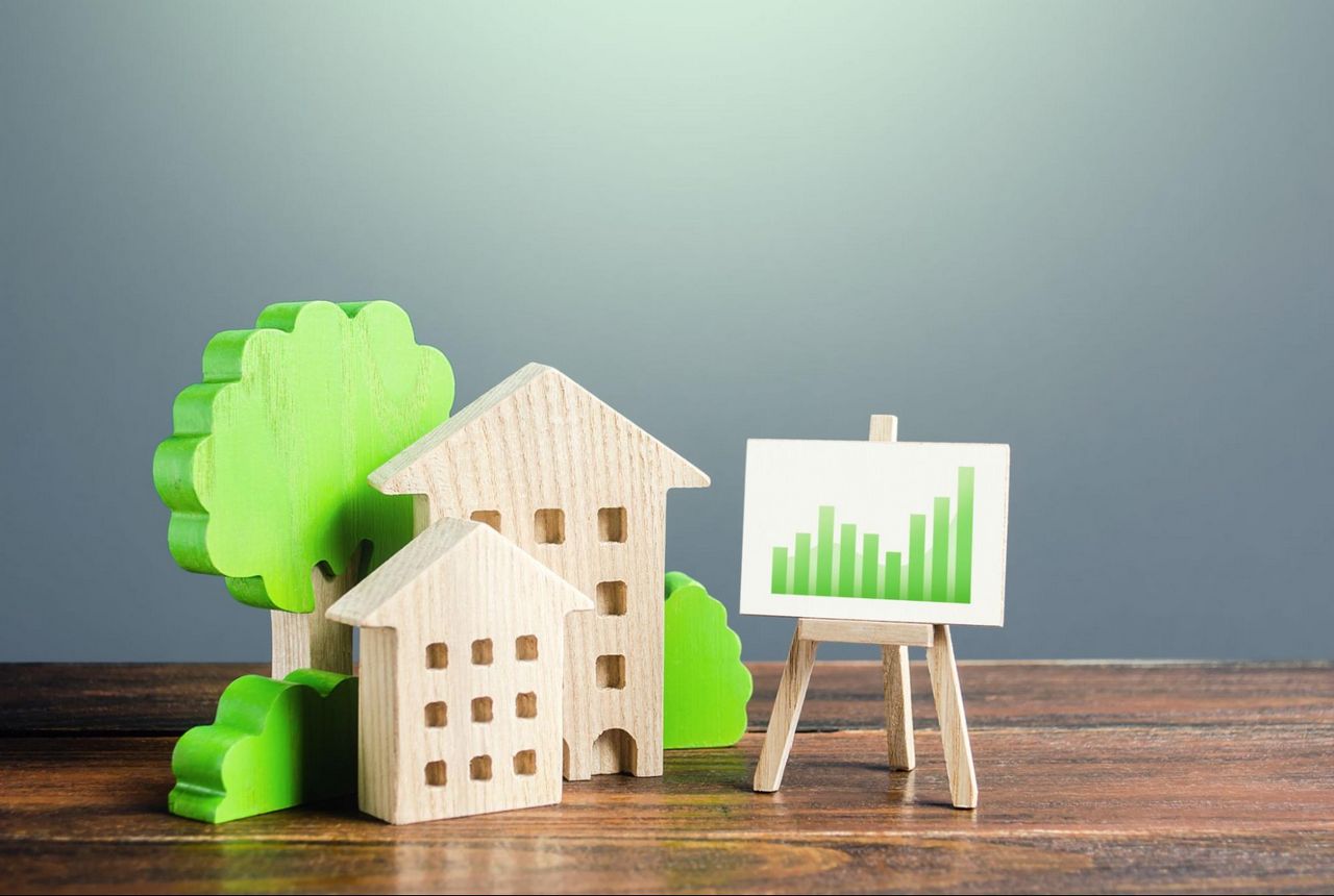 Wooden model homes next to model trees and a graph on a stand.