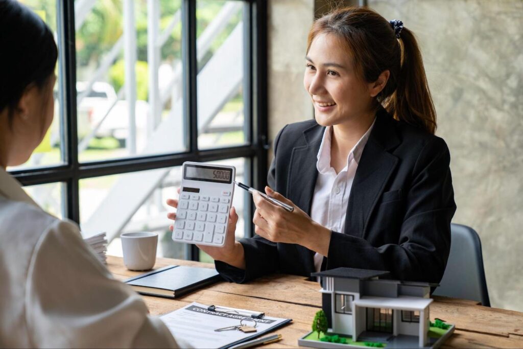 Mortgage expert showing a homeowner the amount of tappable equity their home has on a calculator