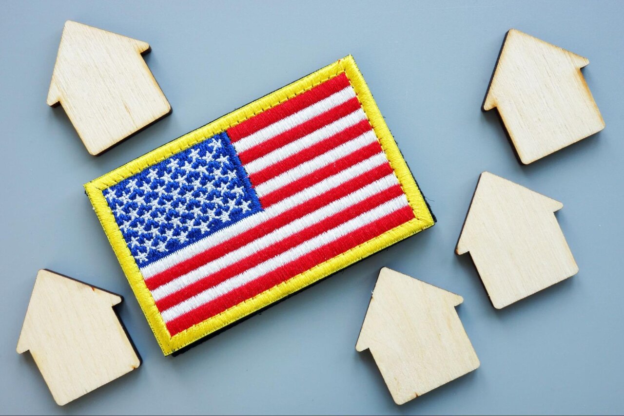 A patch of the american flag surrounded by wooden house cutouts