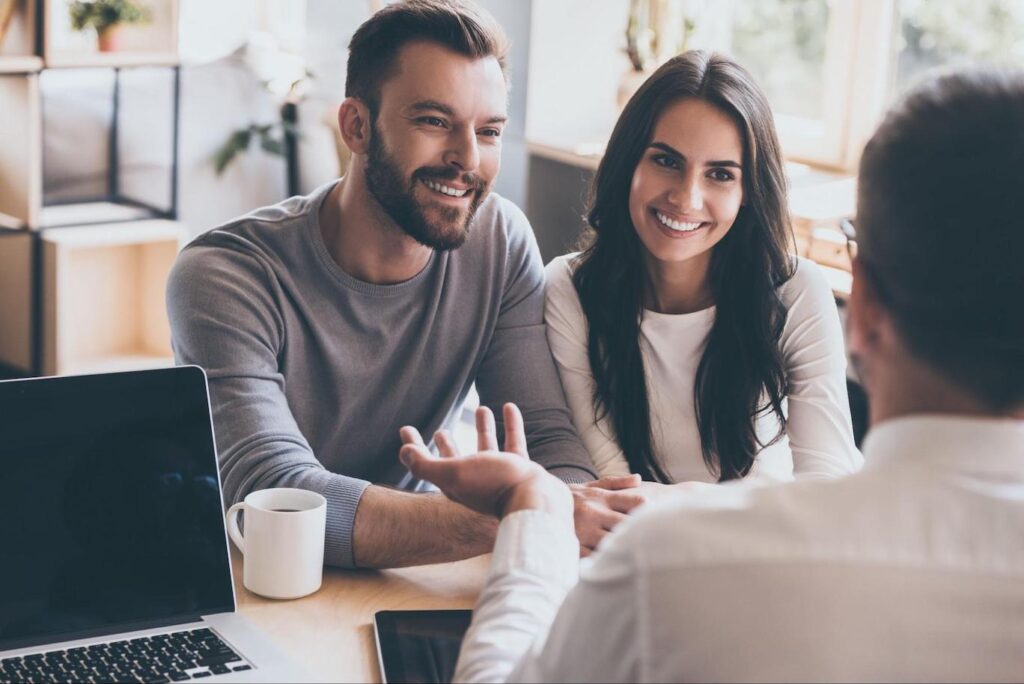 Happy couple speaking with a mortgage professional
