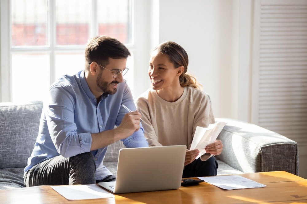 Happy couple saving money on mortgage rate lock extension fees.