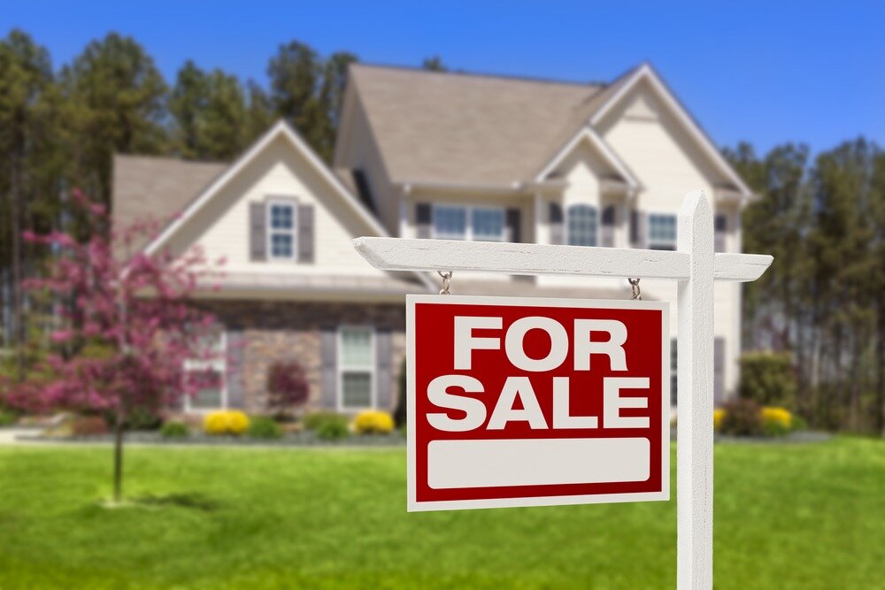 Home for sale sign in front of a house.