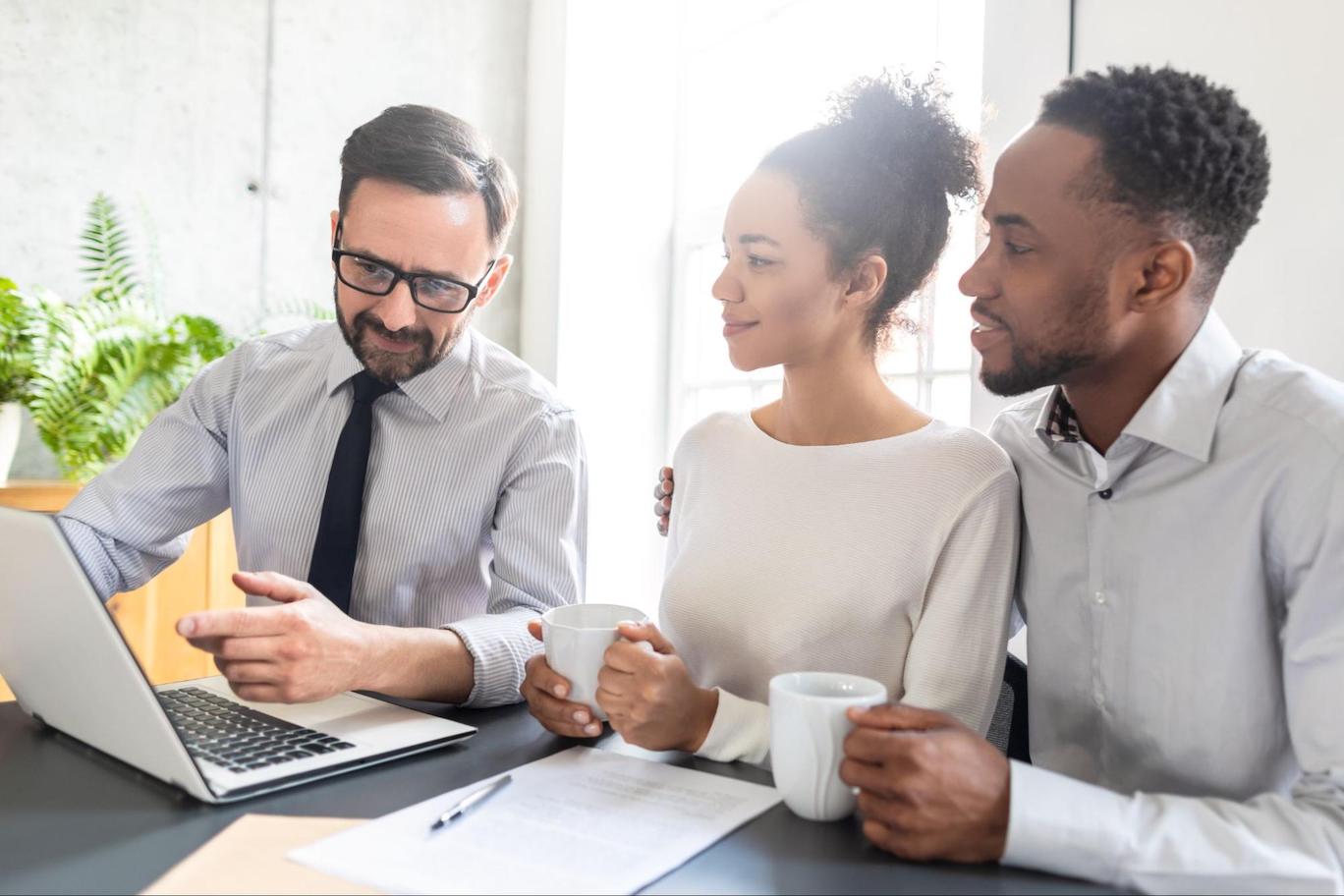 Mortgage professional explaining the types of real estate investments to a young couple.