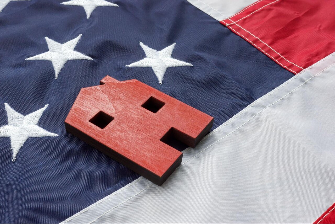 A red cutout of a home on an american flag