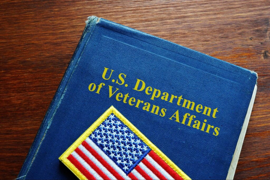 An American flag patch sits on top of a navy blue book that has “U.S. Department of Veterans Affairs” written on it in yellow lettering