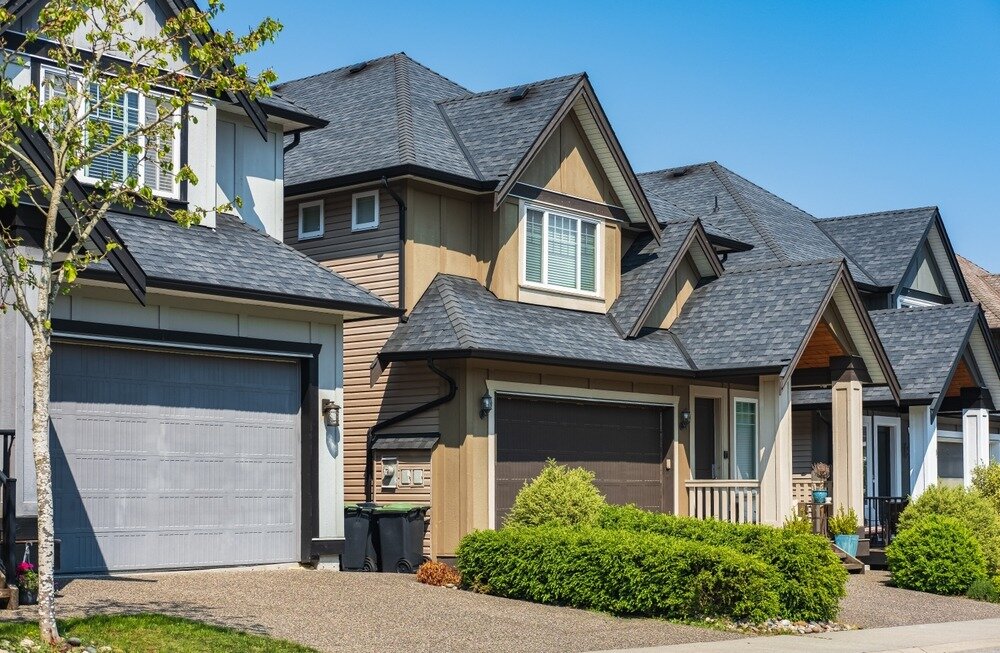 Brown and grey single-family homes in a suburban neighborhood.