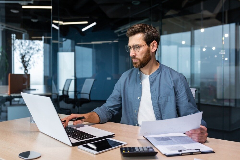 Man calculating how much capital gain tax to pay on real estate.