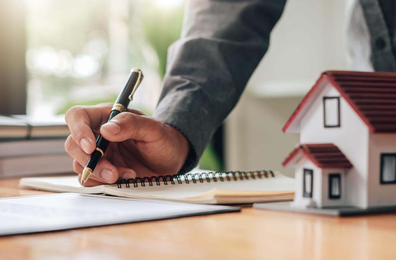 Close up of man taking notes in a mortgage lender’s office