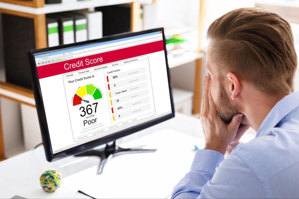 Man sitting at desk looking at his credit report with a score of 367.