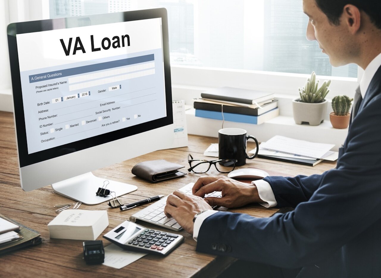 Image of a loan officer sitting at a desk looking at a VA loan application.