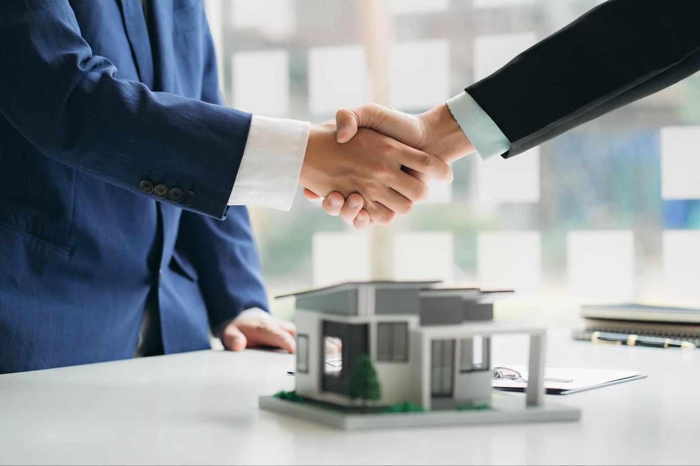 Close up of two people agreeing on a real estate investment deal.