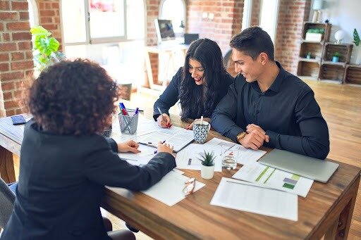 A couple filling out documents with a lender.