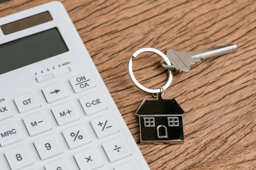 Keys with home keychain next to a calculator
