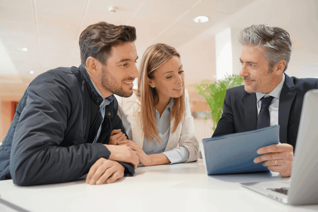A young couple looks at documents with their mortgage lender.