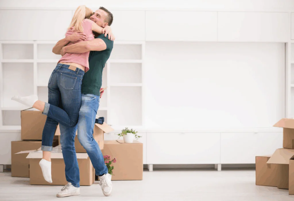 A young couple hug while moving into their new home