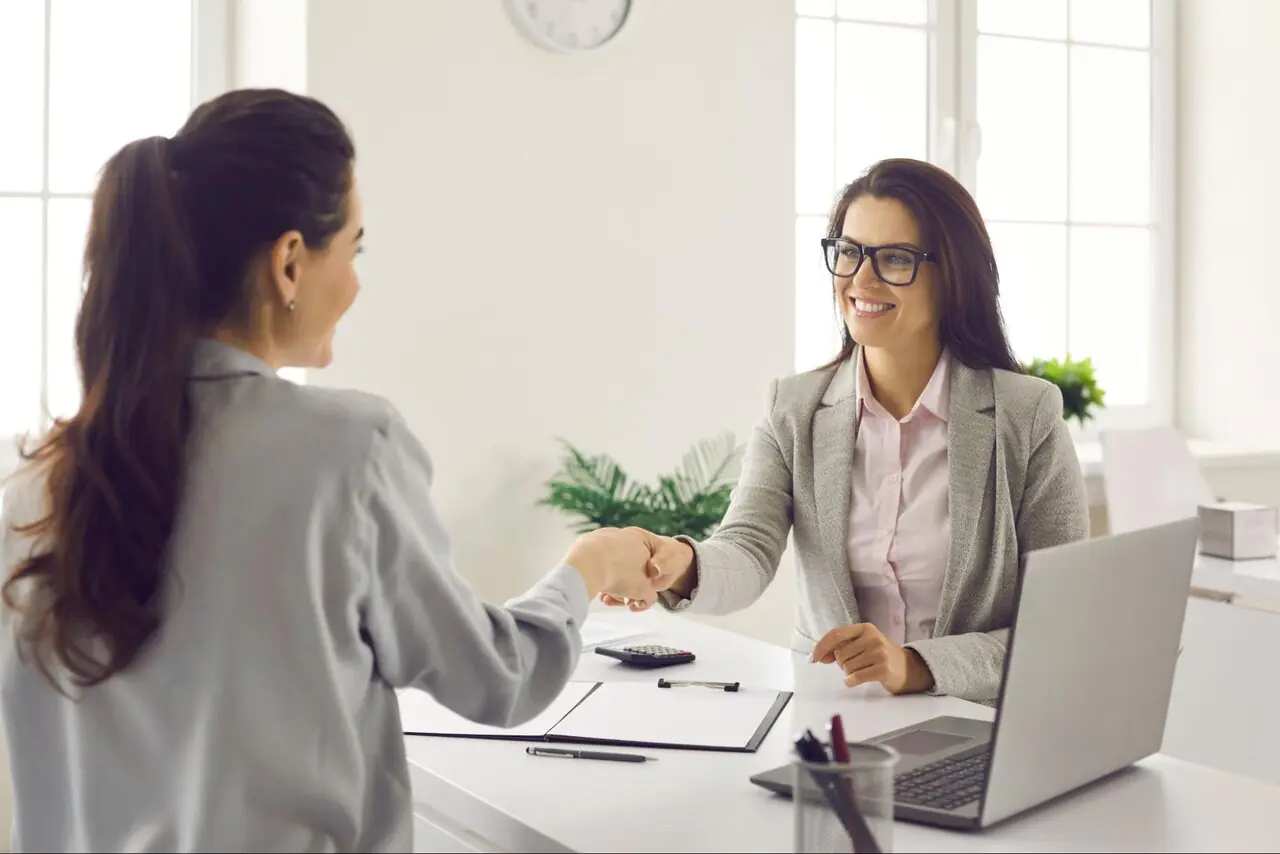 A woman shakes hands with her mortgage lender.